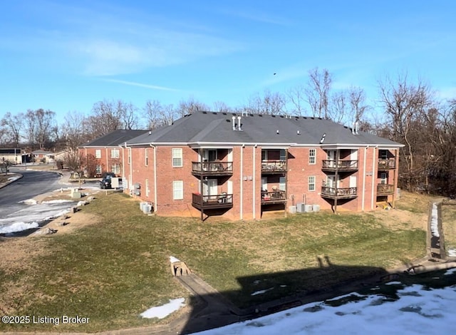 back of property with a balcony and a lawn