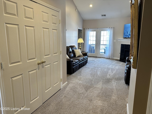 sitting room with a fireplace and light colored carpet