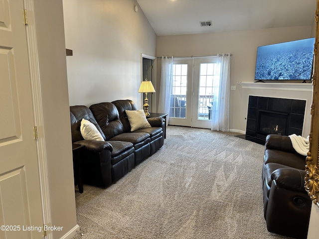 carpeted living room with a fireplace and vaulted ceiling