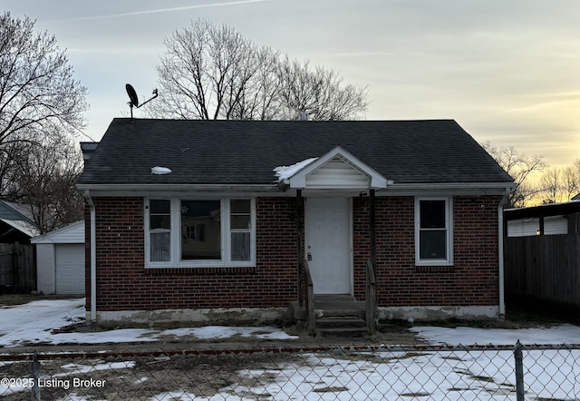 bungalow-style house with a garage and an outbuilding