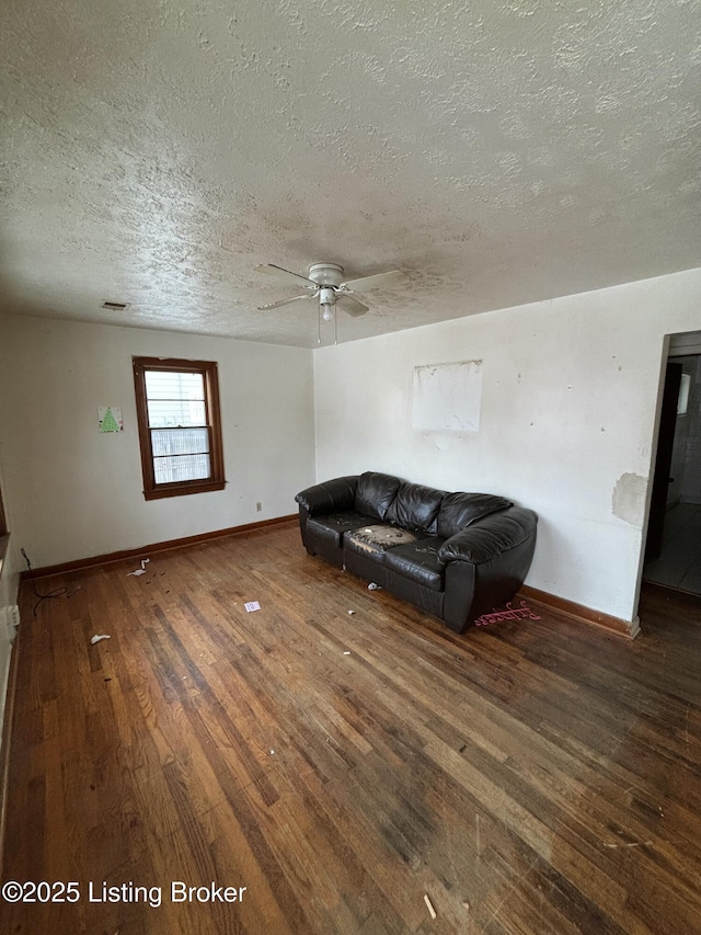 living room with ceiling fan, a textured ceiling, and dark hardwood / wood-style flooring