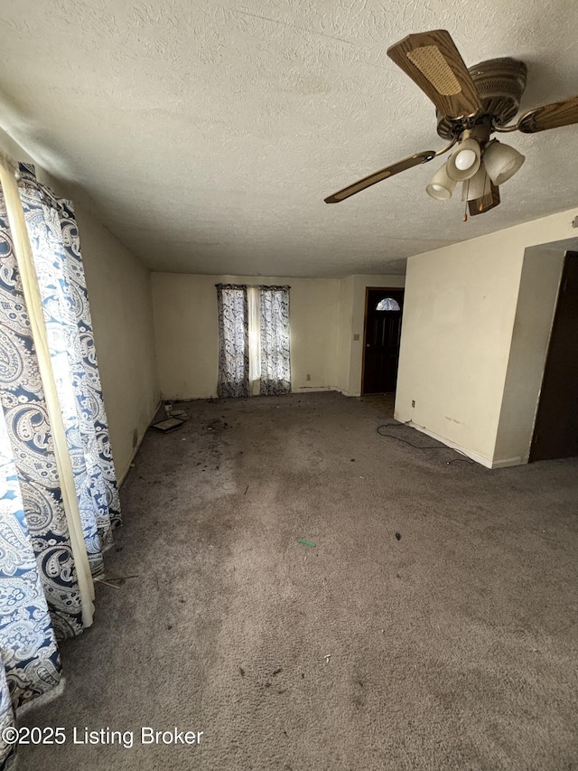 unfurnished living room with ceiling fan, a textured ceiling, and carpet