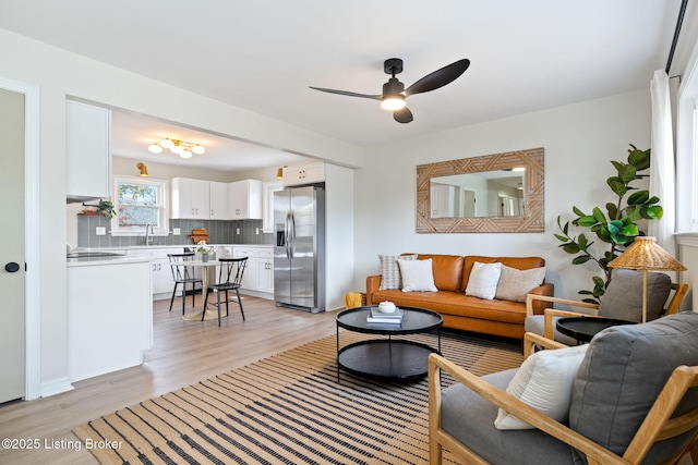 living room with ceiling fan and light wood-type flooring