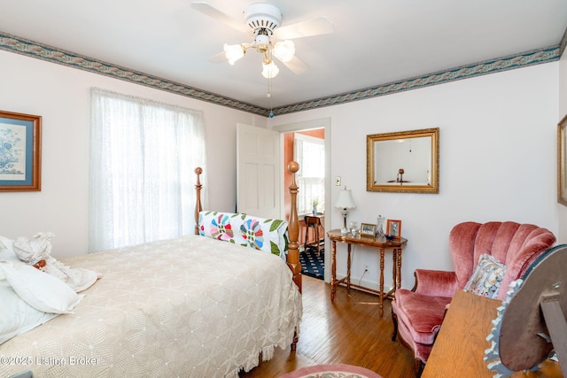 bedroom featuring ceiling fan, hardwood / wood-style floors, and multiple windows