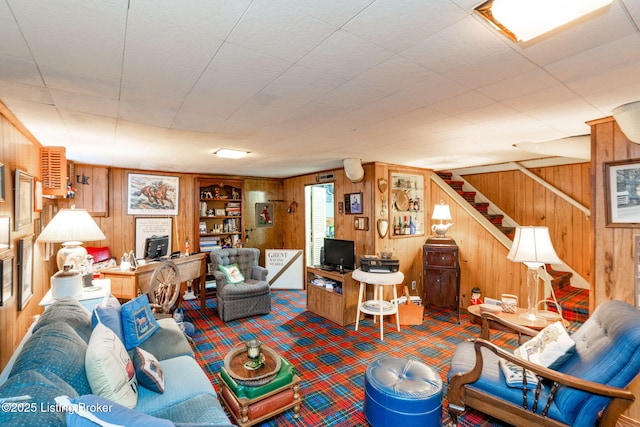 carpeted living room featuring wooden walls and built in features