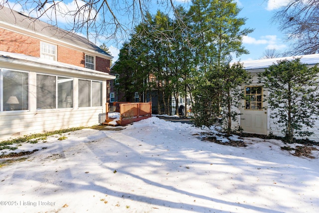 snowy yard featuring a wooden deck