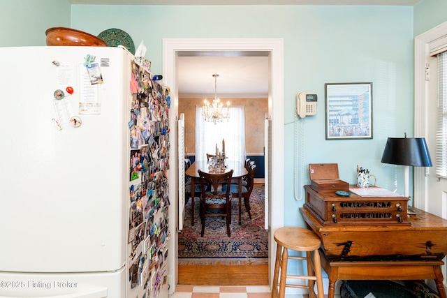 kitchen with ornamental molding, white fridge, a chandelier, and decorative light fixtures