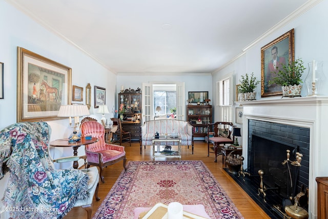 living room with wood-type flooring, a brick fireplace, and crown molding