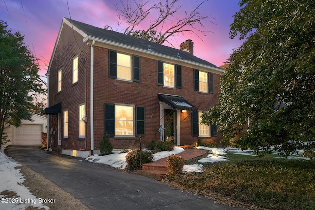 colonial home with a garage and an outdoor structure