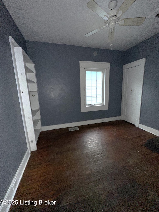 unfurnished bedroom featuring dark wood-type flooring and ceiling fan