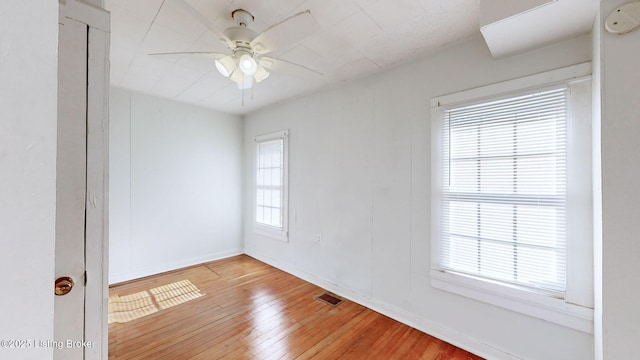 spare room featuring plenty of natural light, light hardwood / wood-style floors, and ceiling fan