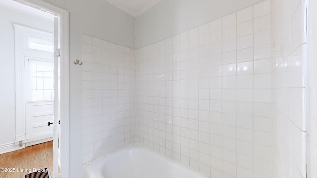 bathroom featuring hardwood / wood-style flooring and shower / bath combination