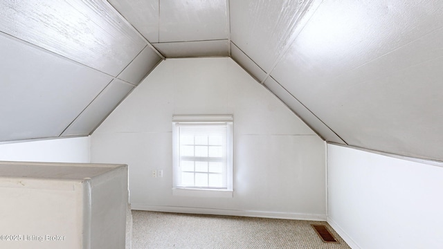 bonus room with vaulted ceiling and carpet