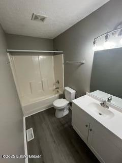 full bathroom with tub / shower combination, hardwood / wood-style floors, toilet, and vanity