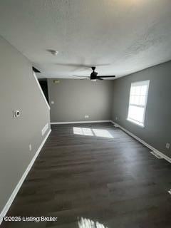 unfurnished room with ceiling fan and dark hardwood / wood-style flooring