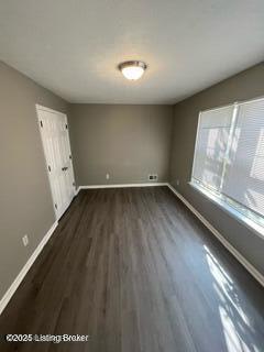 unfurnished room featuring dark hardwood / wood-style flooring