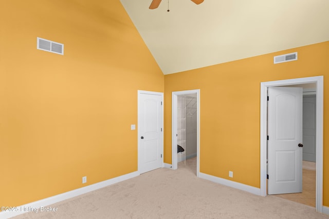 unfurnished bedroom with carpet, a closet, a walk in closet, and vaulted ceiling