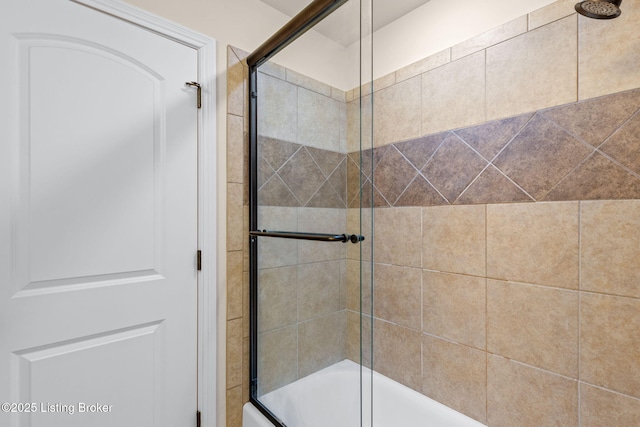 bathroom with bath / shower combo with glass door