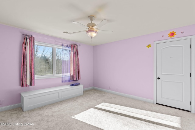 carpeted spare room featuring ceiling fan