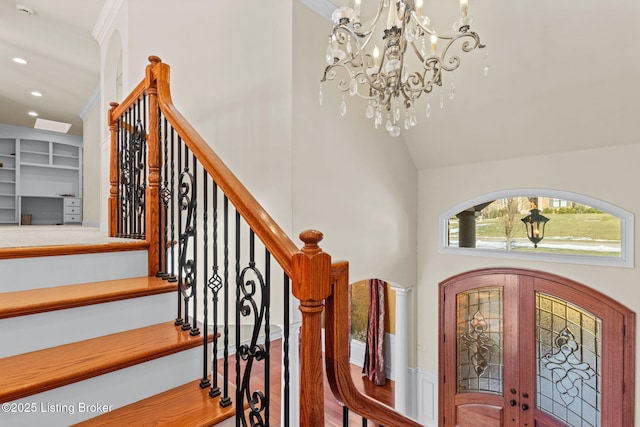 entrance foyer featuring a notable chandelier, french doors, and vaulted ceiling