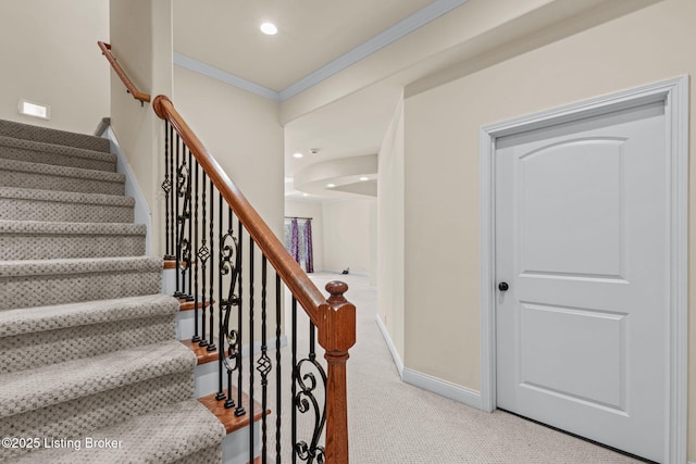 staircase with ornamental molding and carpet flooring