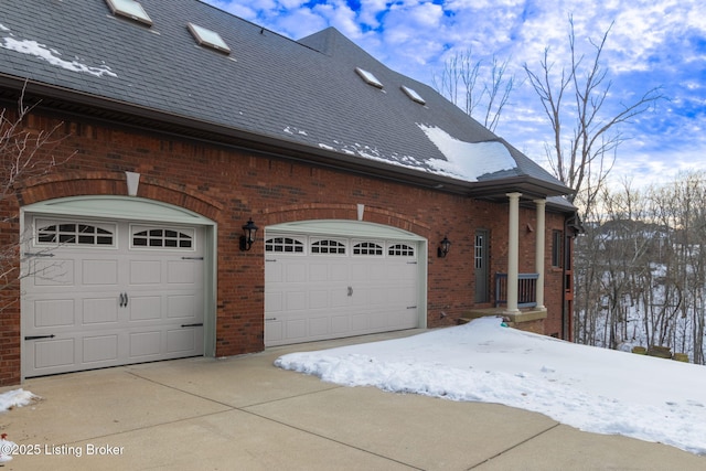 view of snowy exterior featuring a garage