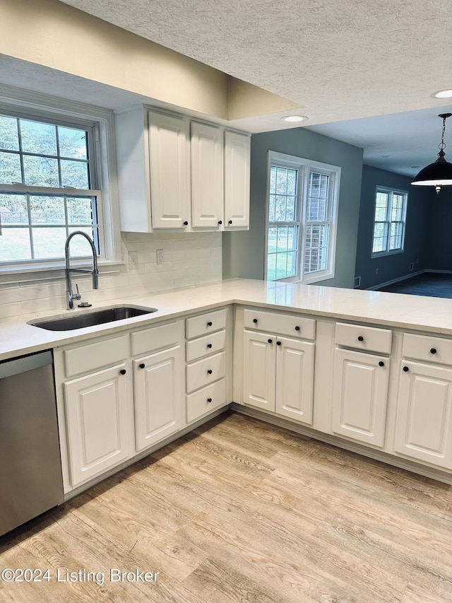 kitchen featuring sink, stainless steel dishwasher, decorative backsplash, and white cabinets