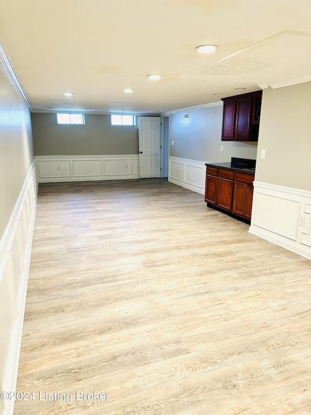 basement featuring light hardwood / wood-style floors and crown molding