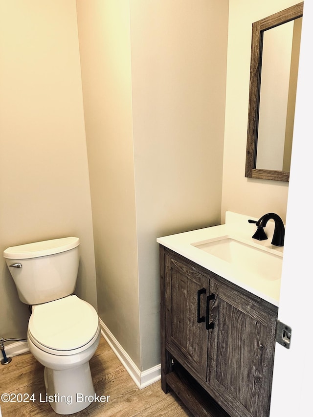 bathroom featuring hardwood / wood-style flooring, toilet, and vanity