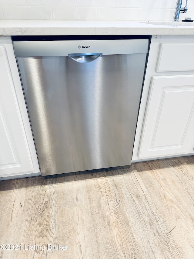 details featuring stainless steel dishwasher, white cabinetry, and light hardwood / wood-style floors