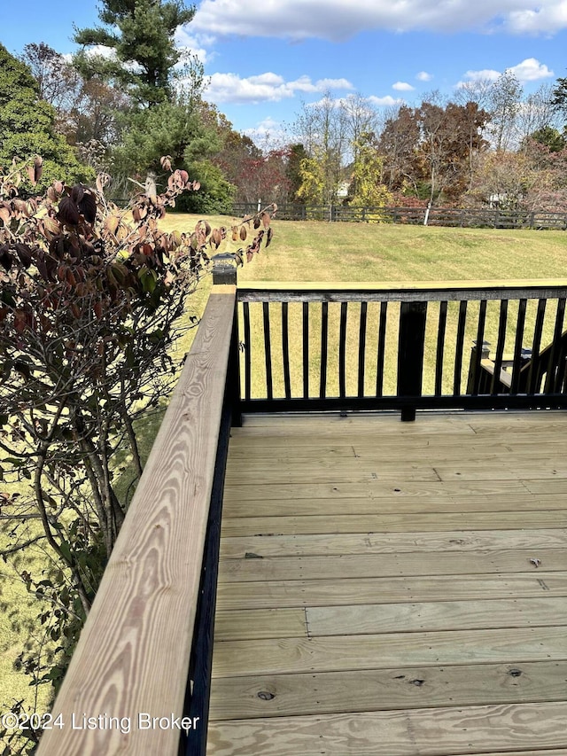 wooden deck featuring a lawn