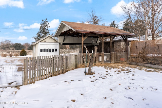 yard covered in snow featuring an outbuilding and a garage