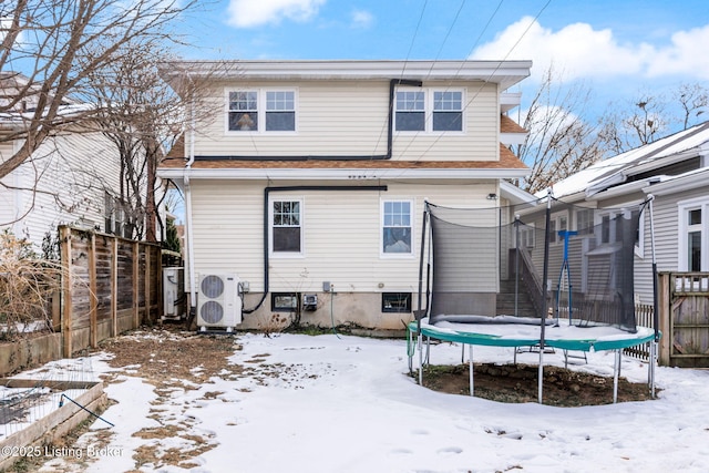 snow covered house with ac unit and a trampoline