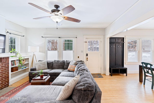 living room featuring light hardwood / wood-style floors, crown molding, and ceiling fan