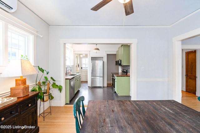 dining room featuring hardwood / wood-style flooring, sink, a wall mounted air conditioner, and a healthy amount of sunlight