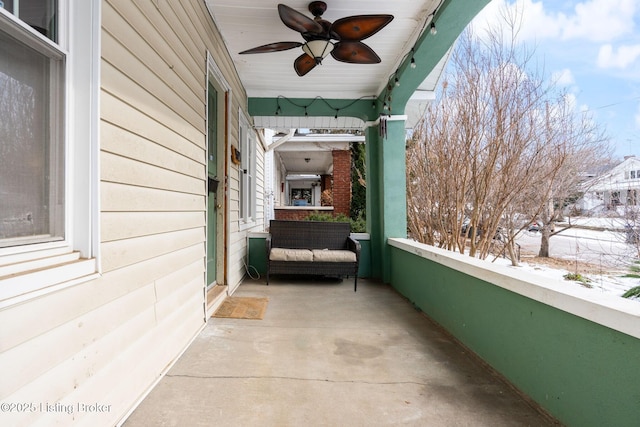 snow covered back of property featuring ceiling fan