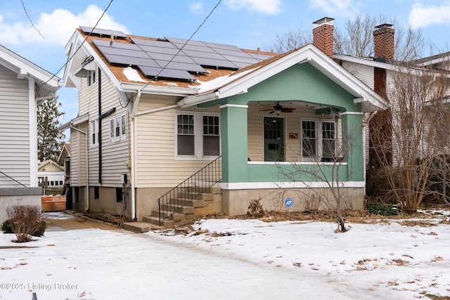 bungalow-style house featuring ceiling fan and solar panels