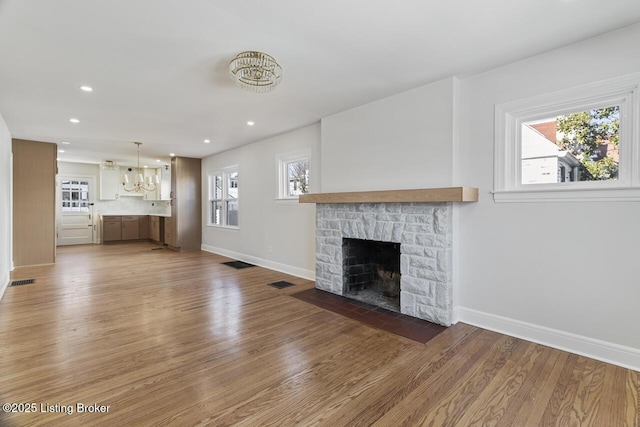 unfurnished living room with a wealth of natural light, hardwood / wood-style floors, and a fireplace