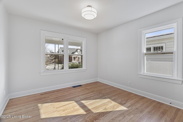 spare room with a healthy amount of sunlight and light hardwood / wood-style flooring