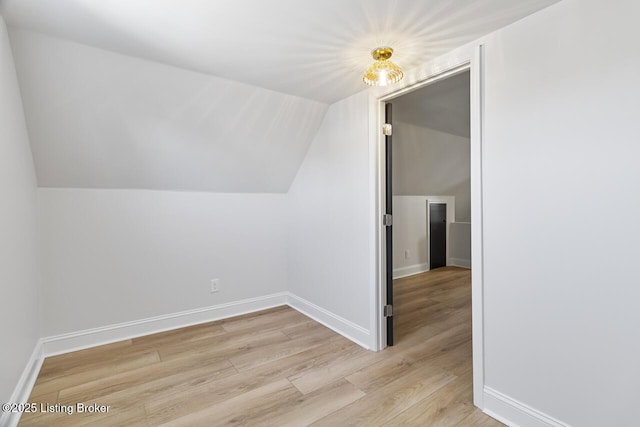 additional living space featuring light hardwood / wood-style floors and lofted ceiling