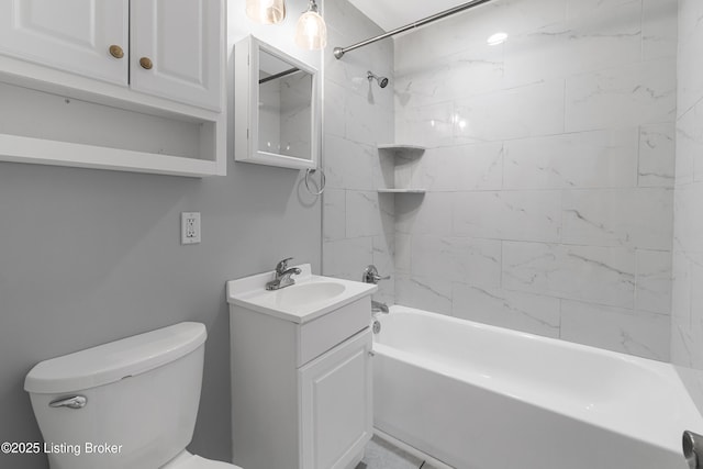 full bathroom featuring tiled shower / bath, vanity, and toilet