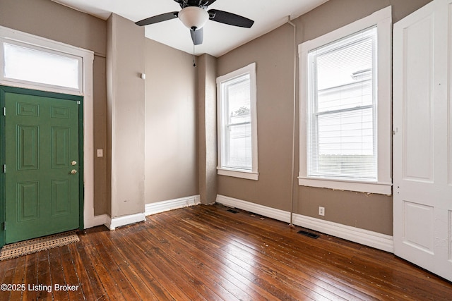 foyer entrance featuring ceiling fan, a wealth of natural light, and dark hardwood / wood-style floors