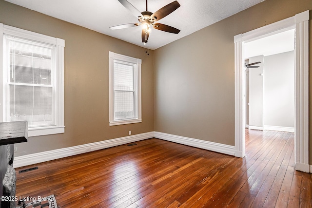 spare room with ceiling fan, a healthy amount of sunlight, and dark hardwood / wood-style floors