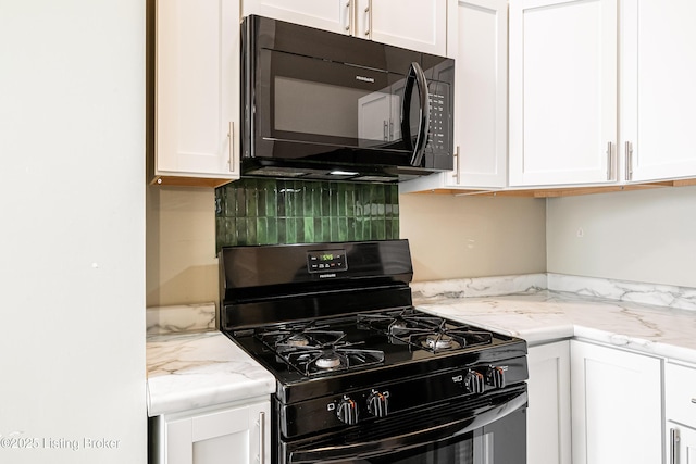 kitchen featuring light stone counters, backsplash, white cabinetry, and black appliances