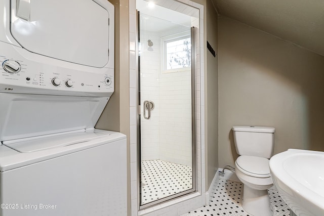 laundry area featuring sink, light tile patterned flooring, and stacked washer and clothes dryer