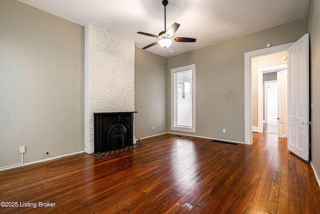 unfurnished living room featuring ceiling fan, a fireplace, and dark hardwood / wood-style flooring