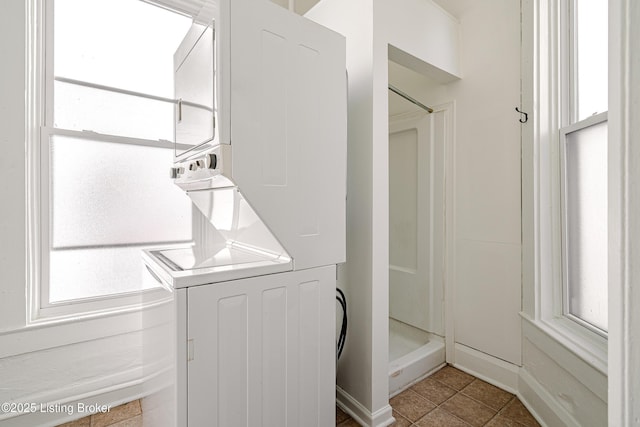 laundry room with stacked washer and clothes dryer and tile patterned flooring