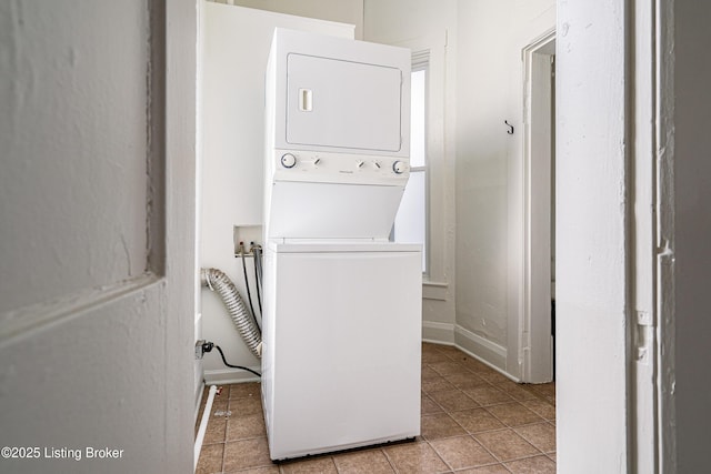 clothes washing area with light tile patterned floors and stacked washer / drying machine