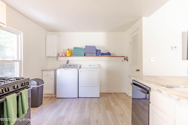 laundry area with washing machine and clothes dryer and light wood-type flooring