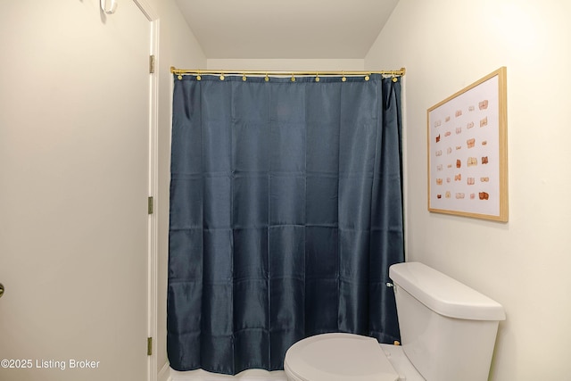 bathroom featuring a shower with curtain and toilet